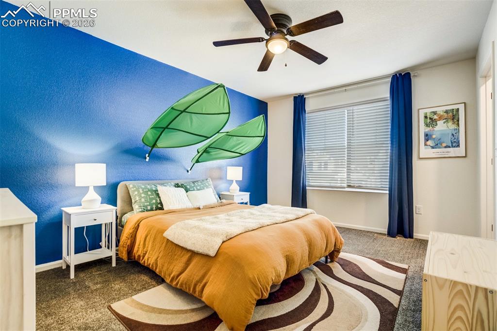 6374 Moate Lane Colorado Springs, CO 80927 - Photo 20 of 42 a bedroom with a bed and a chandelier