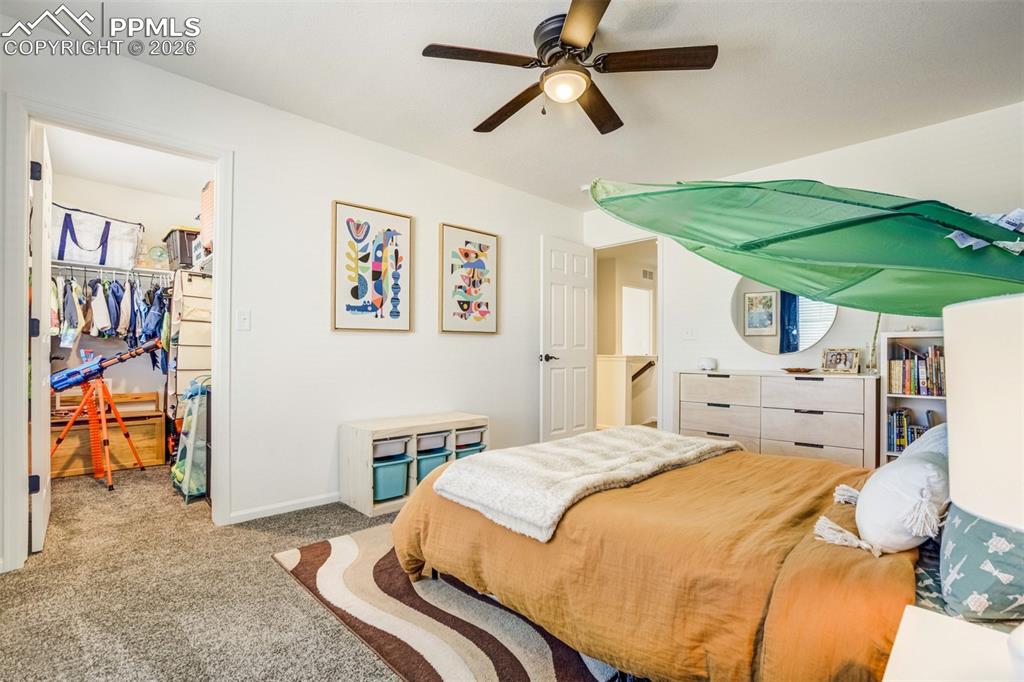 6374 Moate Lane Colorado Springs, CO 80927 - Photo 21 of 42 a bedroom with a bed and a chandelier