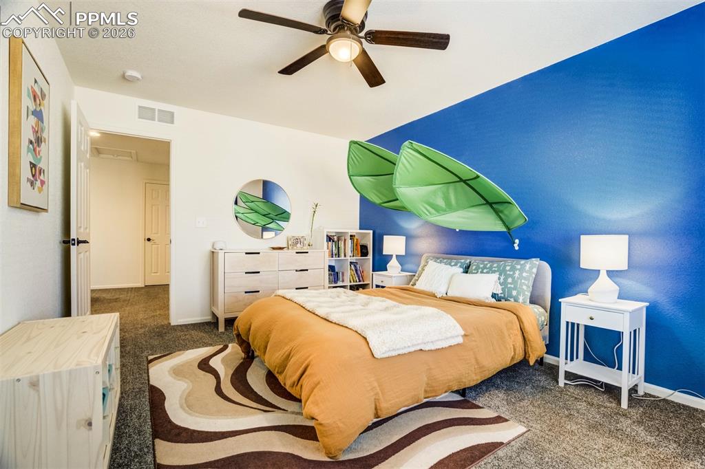 6374 Moate Lane Colorado Springs, CO 80927 - Photo 22 of 42 a bedroom with bed and a chandelier