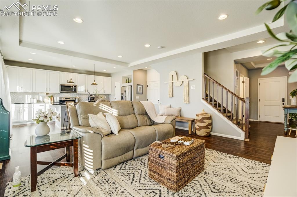 6374 Moate Lane Colorado Springs, CO 80927 - Photo 3 of 42 a living room with furniture wooden floor and a chandelier