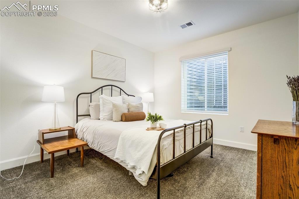 6374 Moate Lane Colorado Springs, CO 80927 - Photo 32 of 42 a bedroom with a bed a dresser and windows