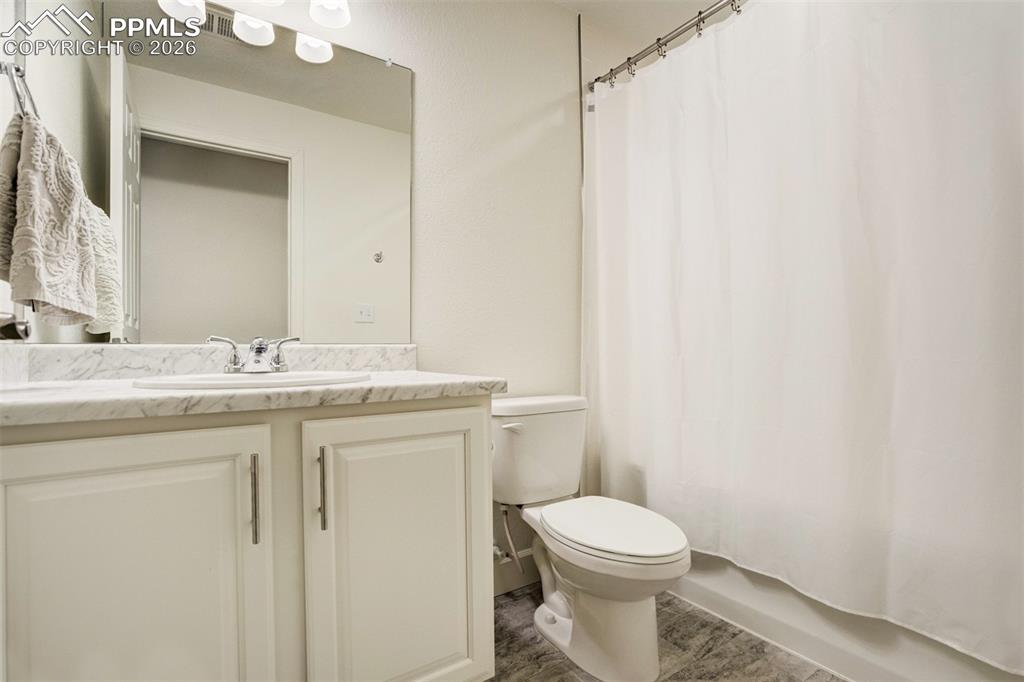 6374 Moate Lane Colorado Springs, CO 80927 - Photo 35 of 42 a bathroom with a granite countertop toilet sink and mirror