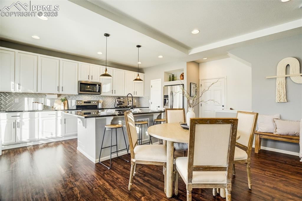 6374 Moate Lane Colorado Springs, CO 80927 - Photo 7 of 42 a kitchen with a table chairs microwave and cabinets