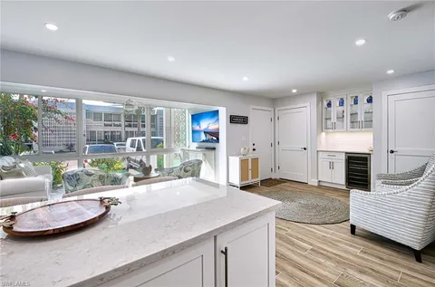 a view of a kitchen with kitchen island a sink appliances and living room view