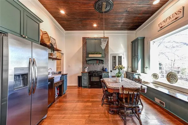 a dining hall with stainless steel appliances granite countertop a stove and refrigerator