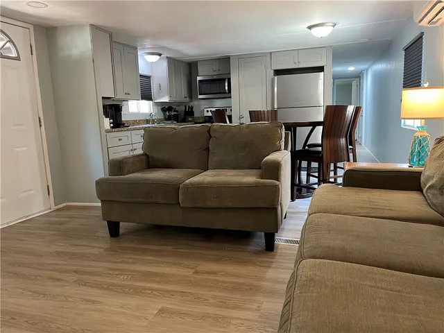 a kitchen with granite countertop white cabinets stainless steel appliances a sink and a window