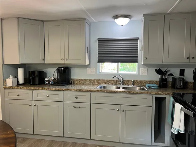 a kitchen with stainless steel appliances granite countertop a refrigerator a stove top oven a sink and dishwasher