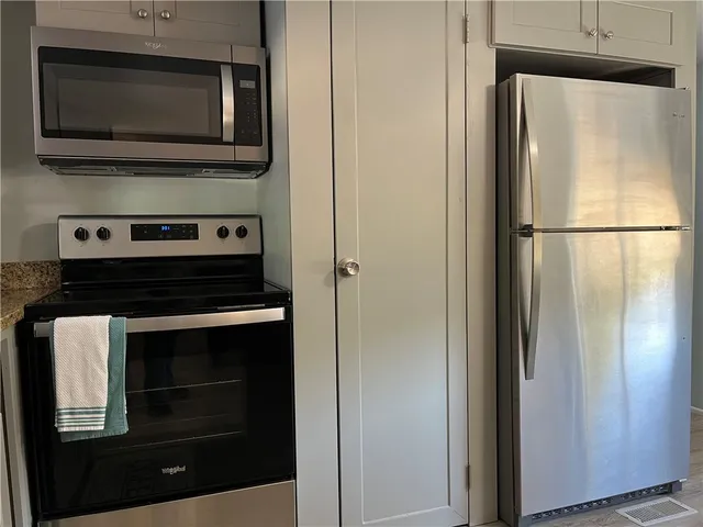 a kitchen with granite countertop white cabinets and white appliances