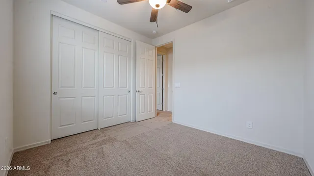 an empty room with a chandelier fan