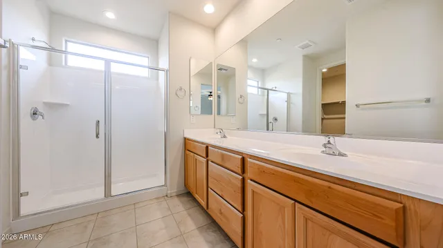 a spacious bathroom with a shower sink and mirror