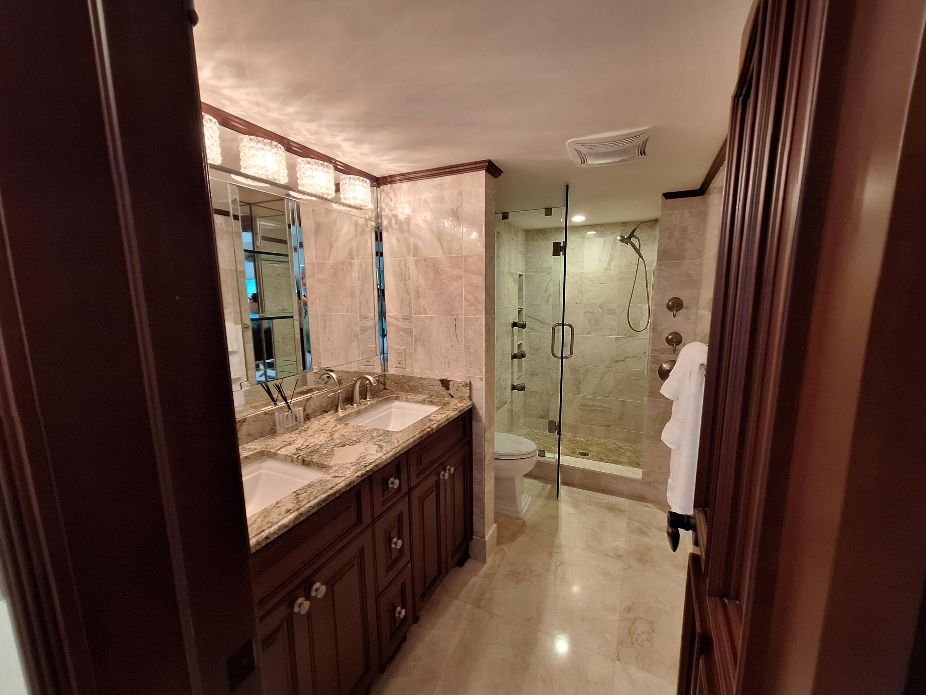 3400 North Ocean Drive, Unit PH2 Singer Island, FL 33404 - Photo 12 of 38 a bathroom with a granite countertop sink a mirror and a bathtub