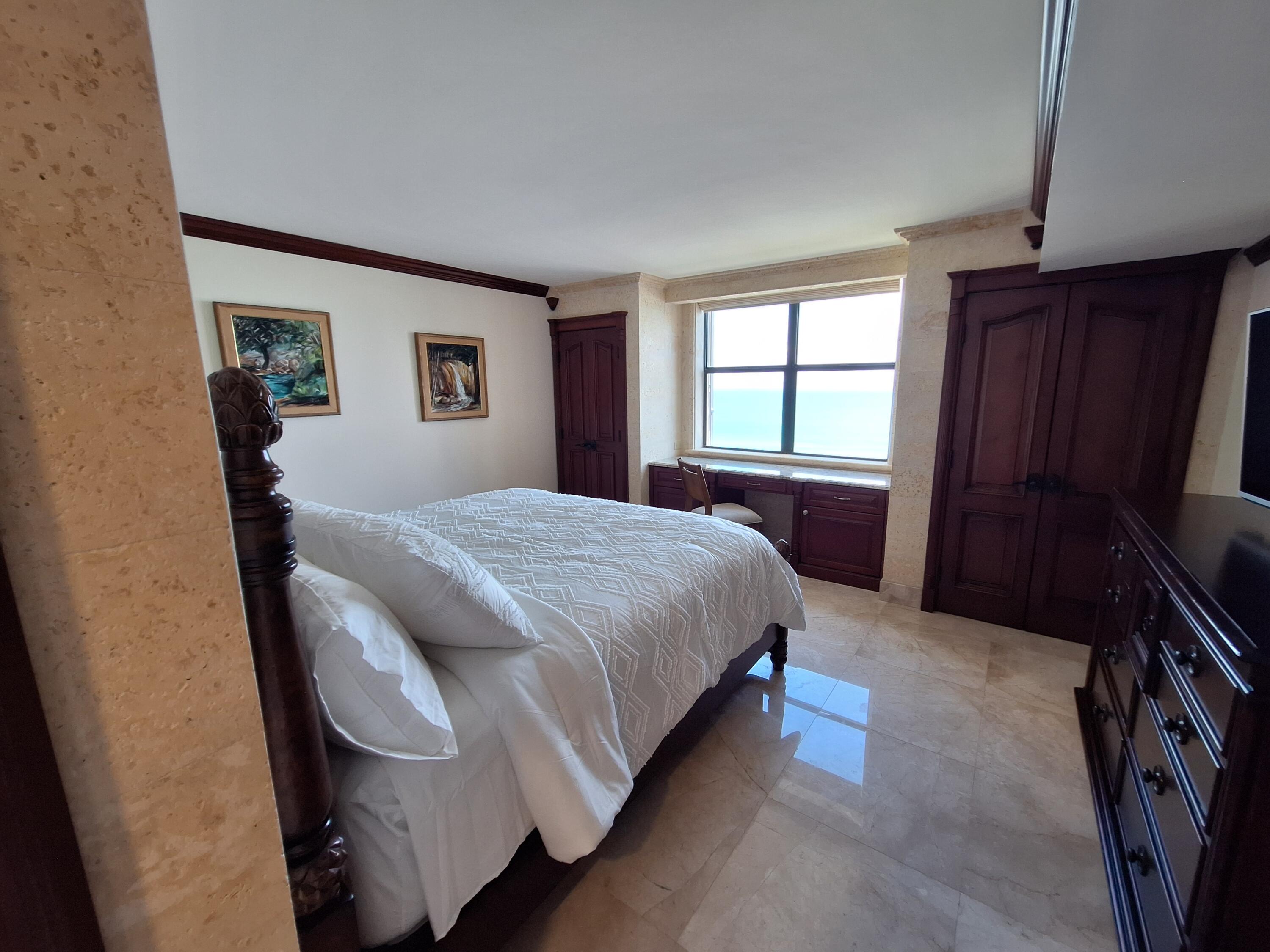 3400 North Ocean Drive, Unit PH2 Singer Island, FL 33404 - Photo 13 of 38 a spacious bedroom with a bed and a window