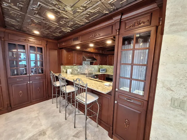 a view of an empty room with wooden floor and furniture