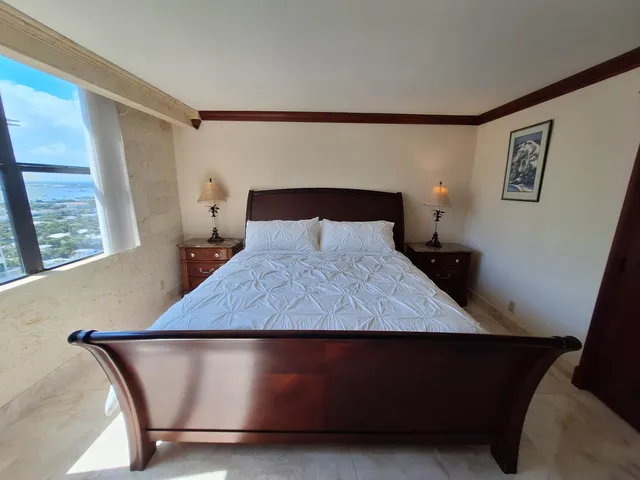 a bedroom with a bed a flat screen tv and dresser