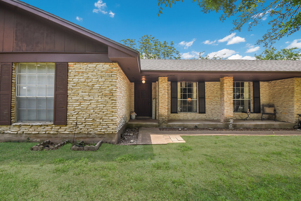 301 Navajo Trail Georgetown, TX 78633 - Photo 7 of 35 Doorway to property featuring a lawn, brick siding, covered porch, and a shingled roof