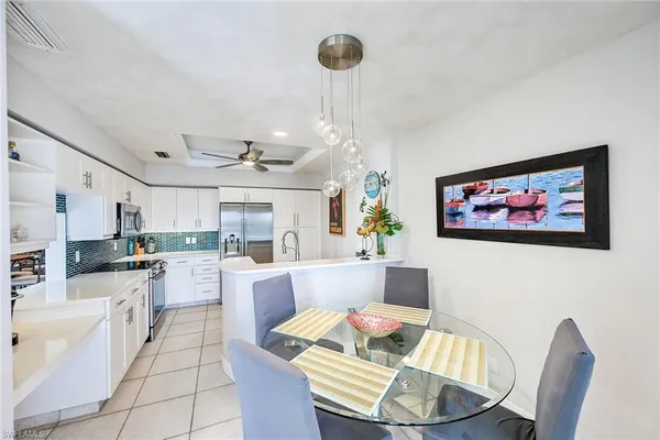 a living room with couches a dining table and kitchen view with wooden floor