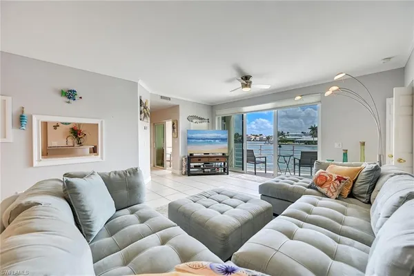 a living room with furniture a couch and a ceiling fan