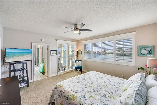 a bedroom with a bed and a large window with the outer view