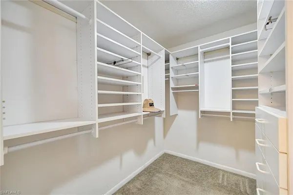 a view of walk in closet with empty racks