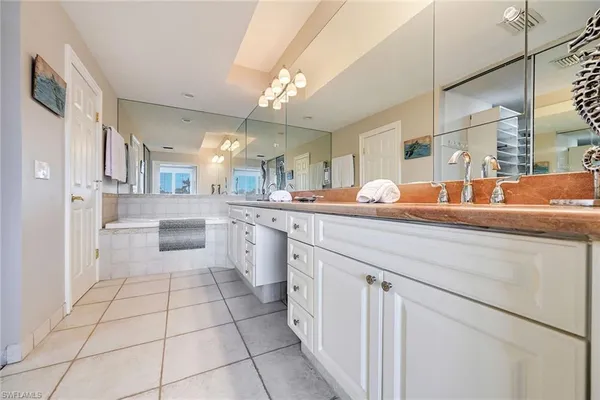 a large white kitchen with a sink and cabinets