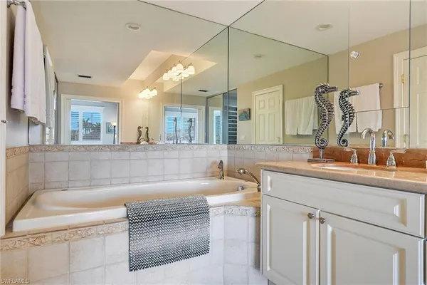 a bathroom with a tub sink and mirror