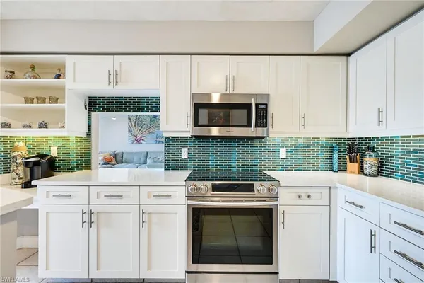 a kitchen with appliances a sink and cabinets