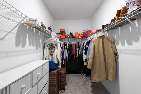 a view of walk in closet with clothes and shoes