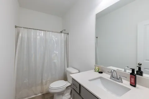 a bathroom with a sink toilet and a mirror
