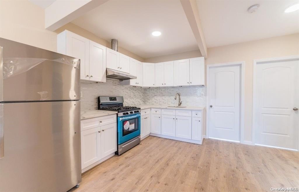 3434 Fulton Street Brooklyn, NY 11208 - Photo 11 of 11 a kitchen with granite countertop a refrigerator stove top oven and sink