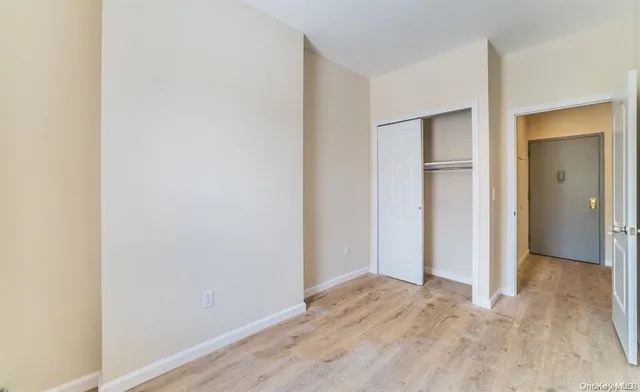 a view of hallway with closet and wooden floor