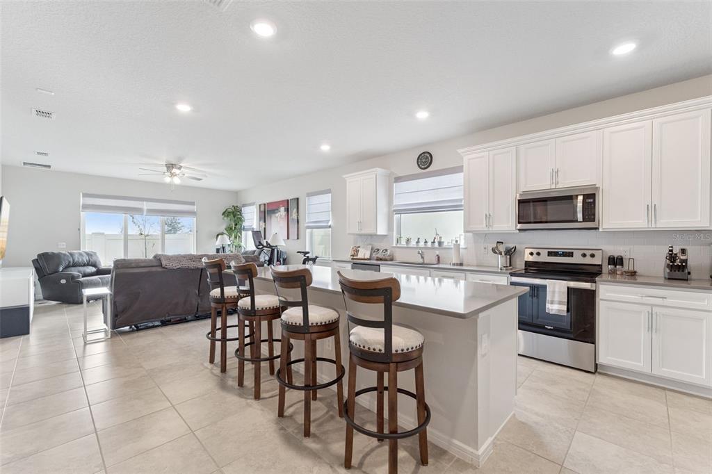 1989 Spring Shower Circle Kissimmee, FL 34744 - Photo 14 of 63 a large white kitchen with lots of furniture a sink and appliances