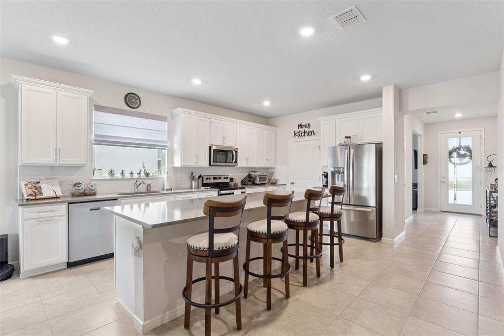 1989 Spring Shower Circle Kissimmee, FL 34744 - Photo 15 of 63 a kitchen with stainless steel appliances kitchen island granite countertop a stove a sink a refrigerator and a refrigerator