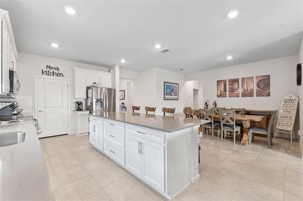 1989 Spring Shower Circle Kissimmee, FL 34744 - Photo 17 of 63 a large white dining hall with stainless steel appliances granite countertop a large center island and a sink