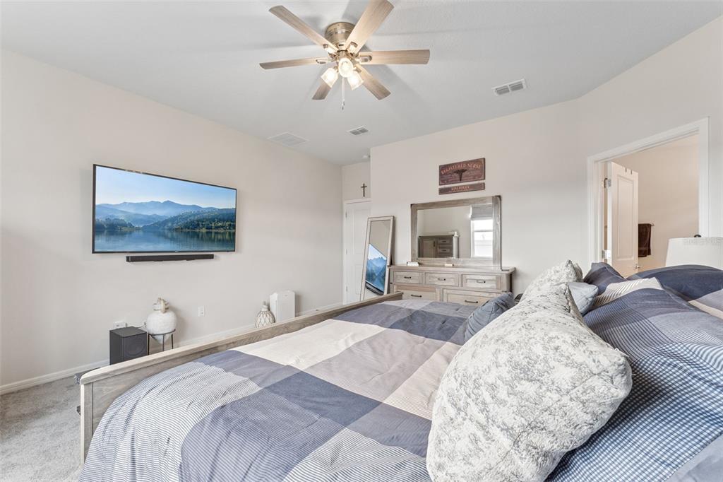 1989 Spring Shower Circle Kissimmee, FL 34744 - Photo 23 of 63 a bedroom with a large bed and a chandelier