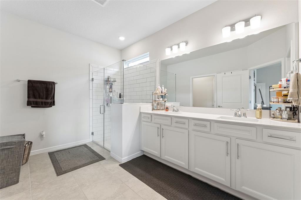 1989 Spring Shower Circle Kissimmee, FL 34744 - Photo 24 of 63 a spacious bathroom with a double vanity sink a mirror and a bathtub