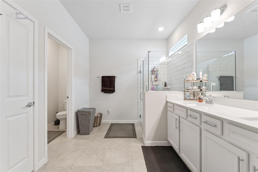 1989 Spring Shower Circle Kissimmee, FL 34744 - Photo 27 of 63 a spacious en suite bathroom with a double vanity sink and mirror