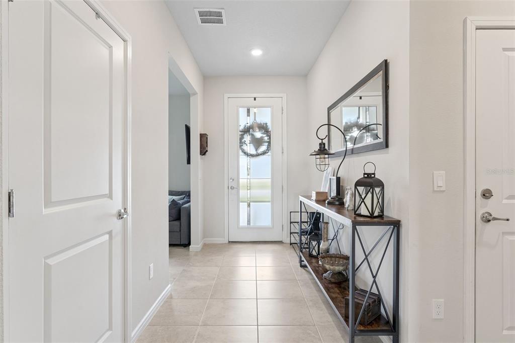1989 Spring Shower Circle Kissimmee, FL 34744 - Photo 4 of 63 a view of a hallway to a livingroom with furniture and front door