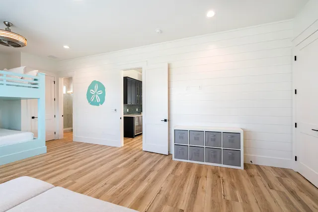 a bedroom with a bed and a large mirror with wooden floor
