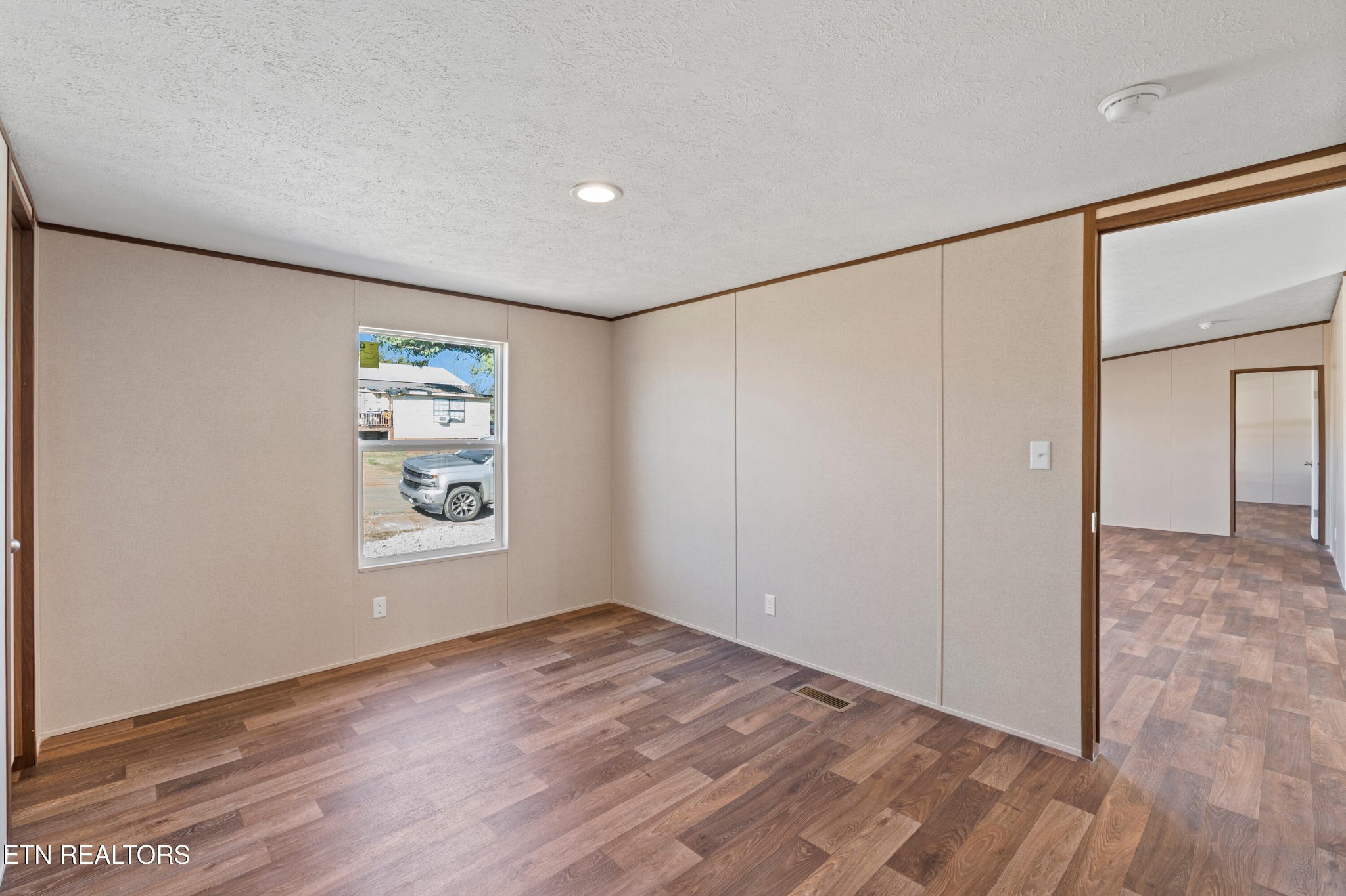 911 Summer Street Loudon, TN 37774 - Photo 23 of 25 a view of an empty room with wooden floor and a window