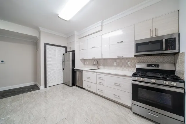 a kitchen with granite countertop a stove top oven microwave and cabinets