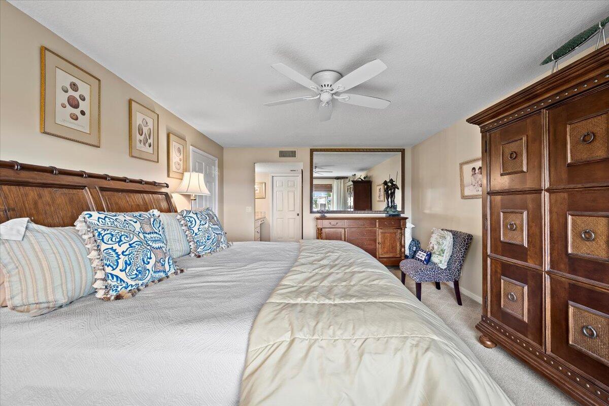 4161 U.S. Highway 1, Unit N3 Jupiter, FL 33477 - Photo 16 of 43 a bed room with a bed a couch and a book shelf