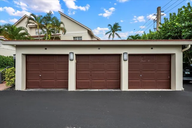 a view of a white house with a big yard and potted plants