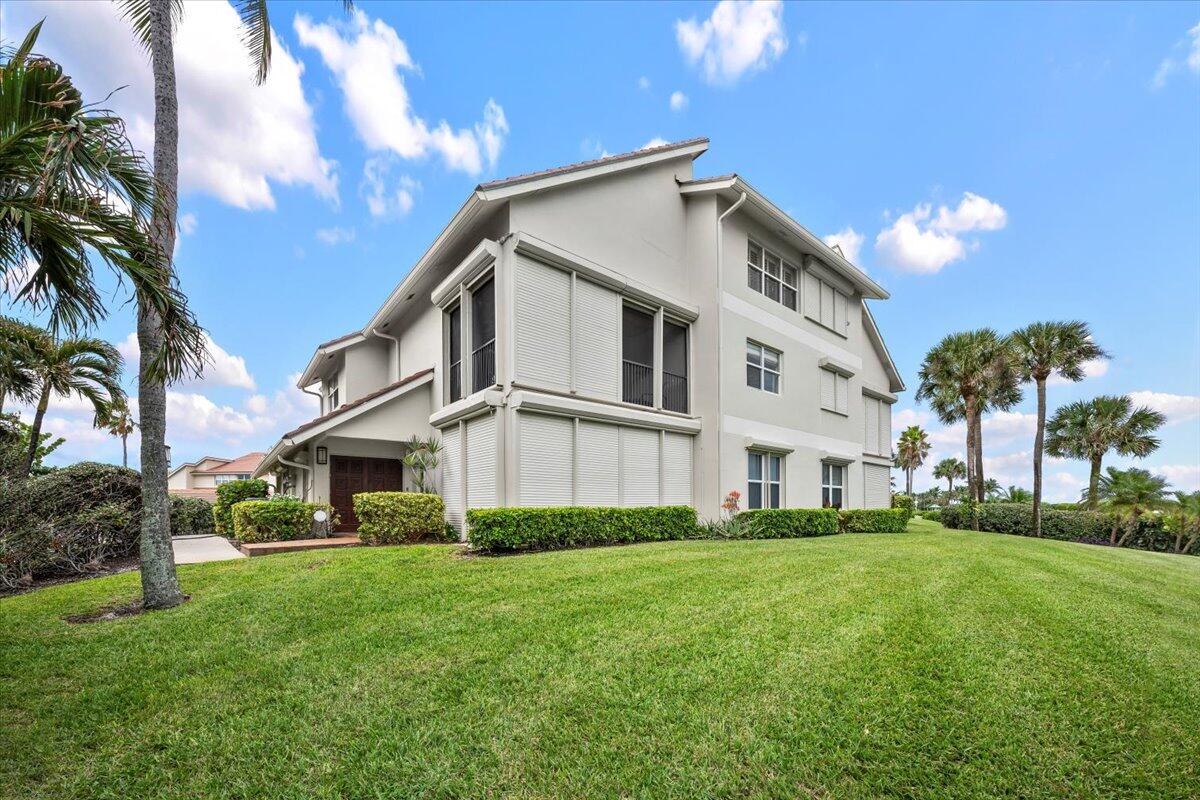 4161 U.S. Highway 1, Unit N3 Jupiter, FL 33477 - Photo 31 of 43 a view of a white house with a big yard and potted plants