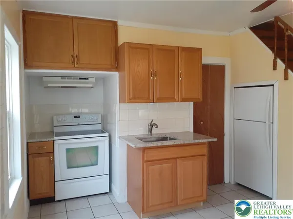 a kitchen with white cabinets and white appliances