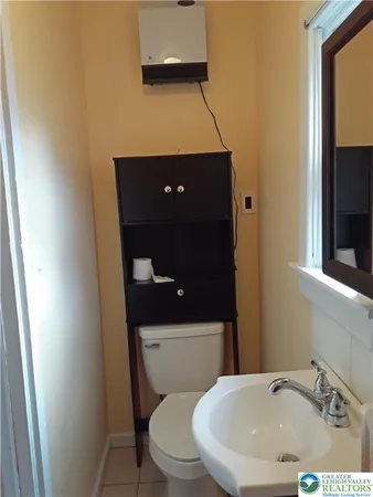 a bathroom with a toilet a sink and mirror
