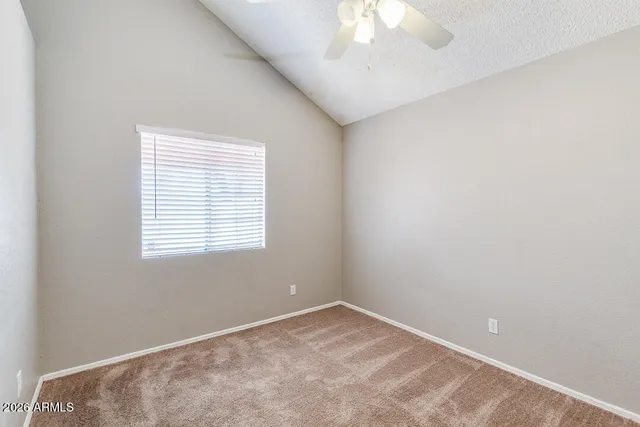 an empty room with a chandelier fan