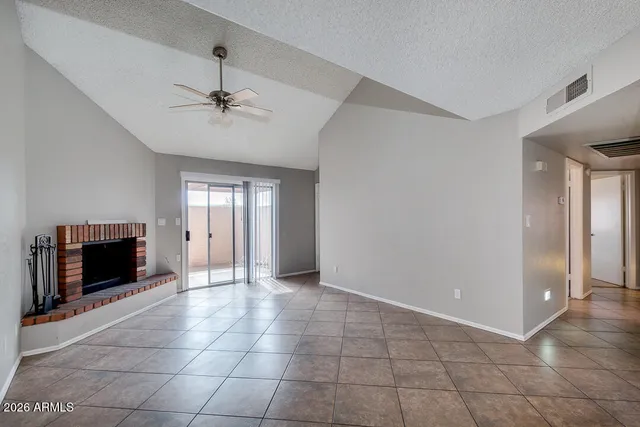 a view of an empty room with a fireplace and a window