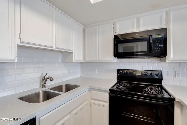 a kitchen with microwave a stove and cabinets