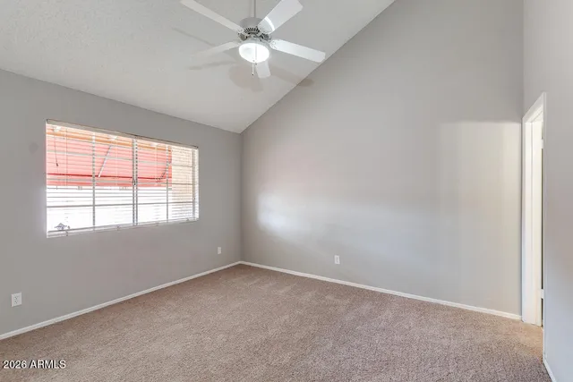 an empty room with a window and a fan