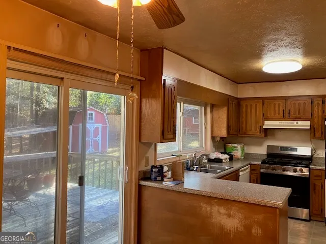 a kitchen with stainless steel appliances kitchen island granite countertop a stove and a sink with granite countertops